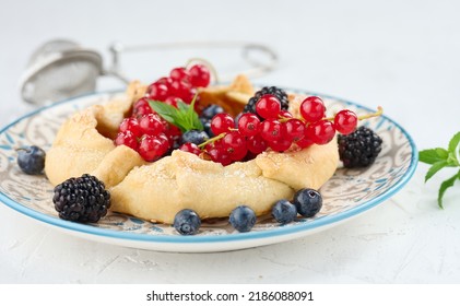 Fruit Tart With Red Currants Sprinkled With Powdered Sugar On A White Table