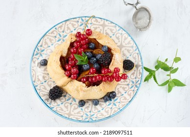 Fruit Tart With Red Currants Sprinkled With Powdered Sugar On A White Table