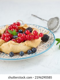 Fruit Tart With Red Currants Sprinkled With Powdered Sugar On A White Table