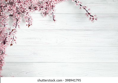 Obstbaumblumen auf weißem Holzhintergrund.