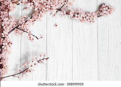Obstbaumblumen auf weißem Holzhintergrund.
