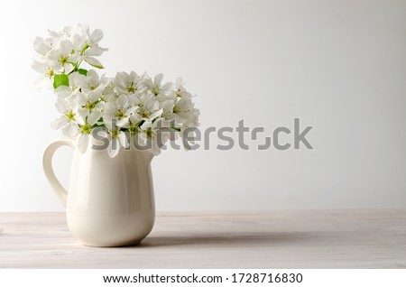 fruit tree pear flowers in a white jar on white table