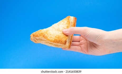 Fruit Turnover Pastry In Hand On Blue Background