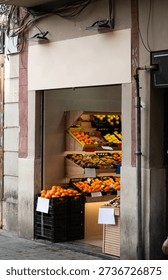 Fruit and vegetable storefront displaying fresh oranges, lemons, kiwi, and other produce in crates, representing local retail and healthy food options