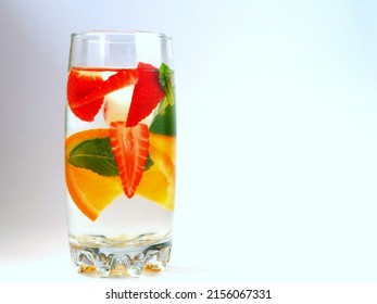 Fruit water with orange, strawberry and mint in a tall glass. Isolated on white background. Ð¡opy space.