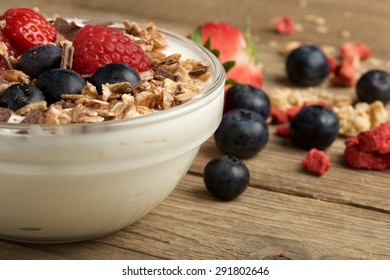 mÃ¼sli with fruit and yogurt on wooden background