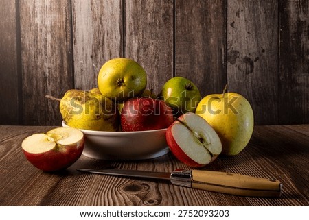 Fruits, apples and pears on a table with ambient light on a wooden table, healthy, organically produced on a farm.