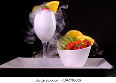 The Fruits in the blow and strawberry on the glass have Dry Ice in the glass set on Black Background. - Powered by Shutterstock