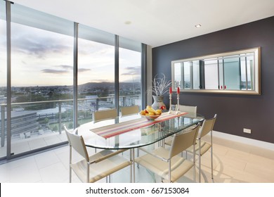 Fruits plate on dining table, comfortable furniture and designs, walls are white color, chairs around the tables, inside rooms of a apartment. - Powered by Shutterstock