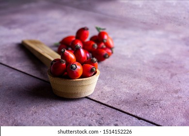 The fruits of rose hip in the wooden spoon. People's medicine. (pometum)