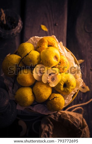 Fruits and twigs quince on a wooden table