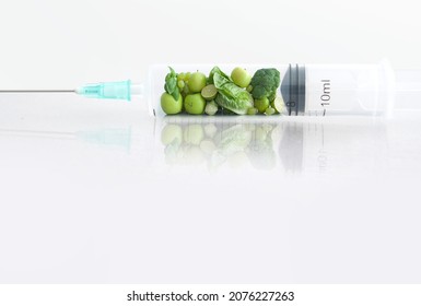 Fruits and vegetables inside an injection needle, nutrition, modified foods, vaccination concept
