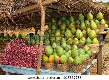 Fruits and vegetables on display for a sale. Market stall. Mango and red onion. Organic food. Beautiful image. 