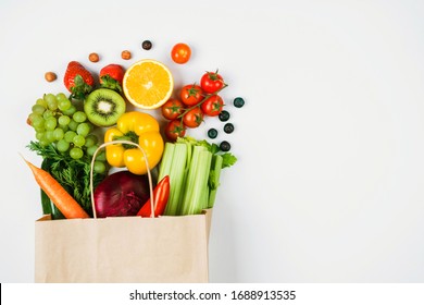 Fruits and vegetables on a light background in a Kraft bag from the store. Healthy and healthy food from the farmers ' market. Space for text - Shutterstock ID 1688913535