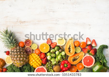 Fruits and vegetables rich in vitamin C, oranges mango grapefruit kiwi kale pepper pineapple lemon sprouts papaya broccoli, on wooden white table, top view, copy space, selective focus