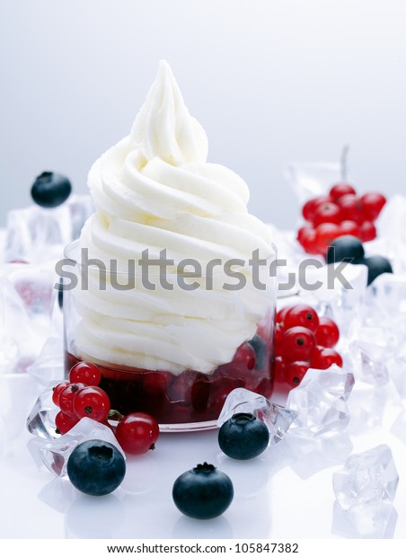 Fruity Frozen Yogurt Dessert with redcurrants and\
blueberries in a glass