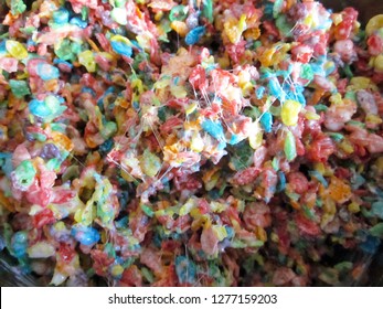 Fruity Pebbles Cereal Being Mixed With Marshmallow To Create The Final Treat