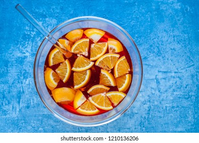 Fruity Punch In Glass Bowl On Blue Table, Top View.  Orange Cocktail. 