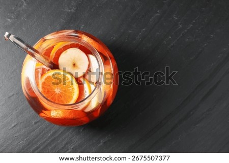 Fruity punch on black table, top view with space for text. Refreshing drink