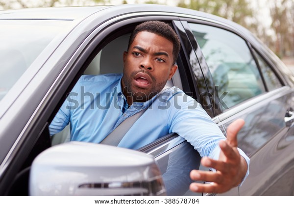 Frustrated African\
American male driver in\
car