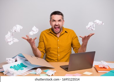 Frustrated angry agent man work home quarantine sit desk cant finish start-up development project crumple paper throw air fly fall scream wear yellow shirt isolated gray color background - Powered by Shutterstock