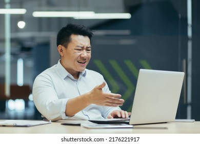 Frustrated And Angry Asian Businessman Talking On Video Call, Man Arguing And Looking At Laptop Screen, Online Business Conference.