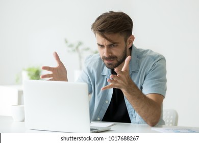 Frustrated angry entrepreneur outraged by laptop problem, furious mad man using computer looking at screen raging after pc software crash error, annoyed guy frustrated disagree with fake online news