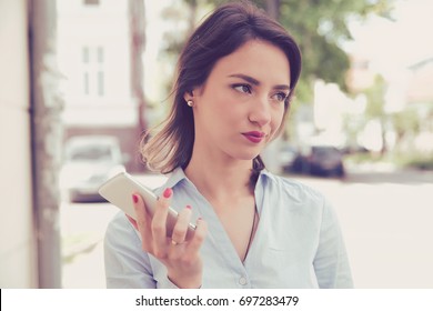 Frustrated Annoyed Sad Woman With Mobile Phone Standing Outside In The Street With An Urban Background