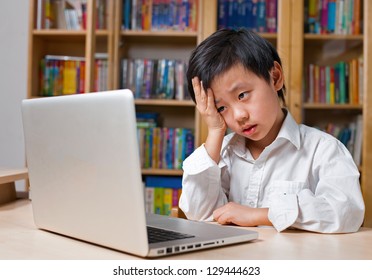 Frustrated Asian School Boy In White Shirt Looking At Laptop Computer