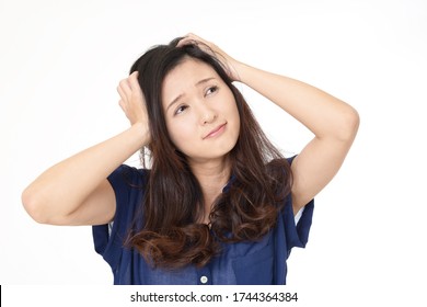 Frustrated Asian woman grabbing her head. - Shutterstock ID 1744364384