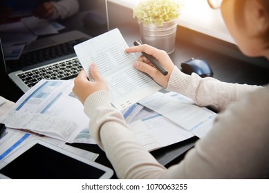 Frustrated Asian woman holding and looking at saving account book, bill and calculating her monthly expenses and Debts at house. Bankrupt Female having problem income, budget, payment. Economic crisis