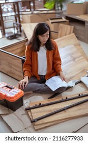 Frustrated Asian Woman While Assembling New Furniture