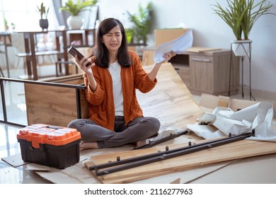 Frustrated Asian Woman While Assembling New Furniture