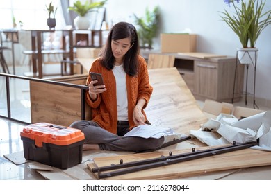 Frustrated Asian Woman While Assembling New Furniture