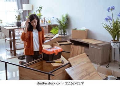 Frustrated Asian Woman While Assembling New Furniture