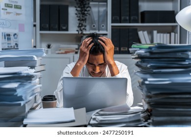 Frustrated Asian young businessman worker working on table in office. Busy employee worker people feel tired and headache from late work and overwork job document on computer desk at company workplace - Powered by Shutterstock