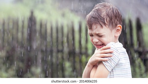 A Frustrated Boy Crying In The Pouring Rain