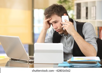 Frustrated Businessman Working On Line With Multiple Devices And Calling Custom Service At Office