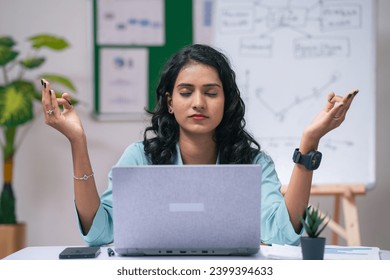 Frustrated businesswoman or employee at office doing meditation at office while working on laptop - concept of mindfulness, self care or wellness and work pressure. - Powered by Shutterstock