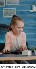 Frustrated Child Attending Online Classes On Computer From Home. Young Girl Feeling Irritated About School Courses And Homework While Using Monitor With Keyboard. Tired Schoolgirl