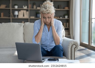 Frustrated concerned mature elder woman worried about finance problems, overspending, money loss, too high price, bankruptcy risk, looking at laptop, calculator in shock