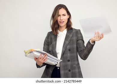 Frustrated And Confused Female Worker And Business Woman Holding A Pile Of Paperwork. Looking Stressed In Camera, Isolated On White Background.