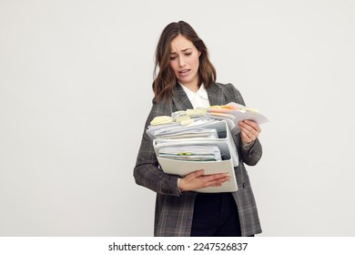 Frustrated and confused female worker and business woman holding a pile of paperwork and feeling stressed.	 - Shutterstock ID 2247526837