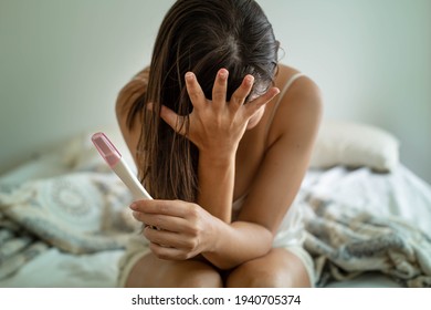 Frustrated disappointed woman holding a negative pregnancy test, difficulties conceiving.