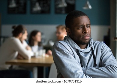 Frustrated excluded outstand african american man suffers from bullying or racial discrimination having no friends sitting alone in cafe, sad depressed black guy upset being rejected by white people - Shutterstock ID 1079701316