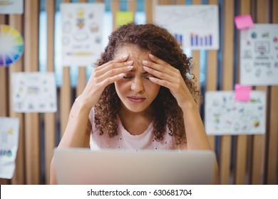 Frustrated female graphic designer with laptop siting at desk in office - Powered by Shutterstock