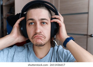Frustrated gamer immersed in gameplay struggles while wearing large headphones at home - Powered by Shutterstock - Get 15% off with code: PIKWIZARD15