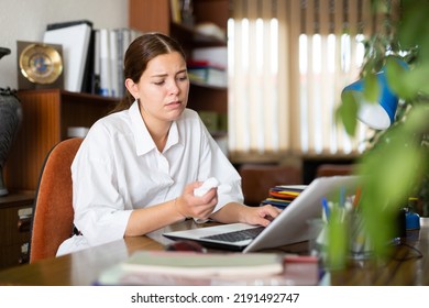 Frustrated Girl Works In The Office Of A Large Company, Sitting At The Workplace At The Computer