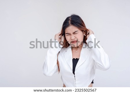 A frustrated and irritated young woman pulling her hair with both hands in annoyance. Isolated on a white background.