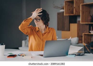 Frustrated Italian Female Employee Stressed About Mistake Or Problem With Computer, Got Bad News From Office. Tired Nervous Spanish Woman Working Remotely Online From Home. Pressure At Work Concept